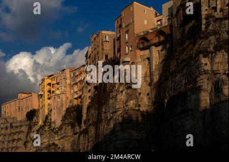 Dunkle Wolken an einem Augustabend über der Altstadt von Tropea, einer alten Siedlung auf den Klippen, die angeblich vom Gott Herkules an der Westküste Kalabriens, Süditalien, gegründet wurde. Die Hochhäuser und Appartements am Rand der Sandsteinklippen sind mit Balkonen und Beliebten übersät und bieten einen herrlichen Blick auf das Tyrrhenische Meer. Stockfoto