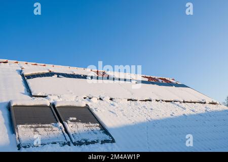 Schneeschmelzen von Sonnenkollektoren auf dem Dach. Stockfoto