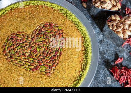 Kanafeh. Türkische Dessertkunefe, Kunafa, Kadayif mit Pistazienpulver und Käse, warm serviert, sehr süß. Traditionelles türkisches Dessert Künefe tatlısı Stockfoto