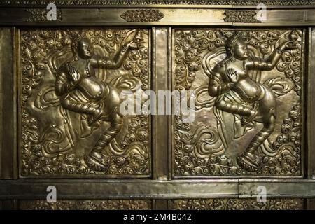 Große geprägte goldene Kupfertafel mit Figuren von Tänzern im Jokhang-Tempel in Lhasa. Autonome Region Tibet. China. Stockfoto