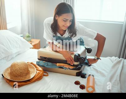 Frau, überladener Koffer und Gepäcktasche im Schlafzimmer für Reise, Urlaub und internationale Reise, Urlaub und Reise. Weibliche Touristen kämpfen darum Stockfoto