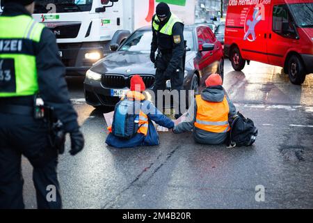 München, Deutschland. 20.. Dezember 2022. Vier Aktivisten der Letzten Generation blockierten die Sonnenstraße in München am 20. Dezember 2022 trotz Anordnung des KVR gegen Kleeblockaden. Im Voraus wurde die Aktion offiziell angekündigt, weshalb viele Polizisten vor Ort waren und 6 weitere Aktivisten stoppten, bevor sie die Straße blockieren konnten. Die Last Generation demonstriert für ein 9-Euro-Ticket und eine Geschwindigkeitsbegrenzung von 100 km/h auf Autobahnen. (Foto: Alexander Pohl/Sipa USA) Guthaben: SIPA USA/Alamy Live News Stockfoto