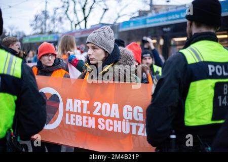 München, Deutschland. 20.. Dezember 2022. Vier Aktivisten der Letzten Generation blockierten die Sonnenstraße in München am 20. Dezember 2022 trotz Anordnung des KVR gegen Kleeblockaden. Im Voraus wurde die Aktion offiziell angekündigt, weshalb viele Polizisten vor Ort waren und 6 weitere Aktivisten stoppten, bevor sie die Straße blockieren konnten. Die Last Generation demonstriert für ein 9-Euro-Ticket und eine Geschwindigkeitsbegrenzung von 100 km/h auf Autobahnen. (Foto: Alexander Pohl/Sipa USA) Guthaben: SIPA USA/Alamy Live News Stockfoto