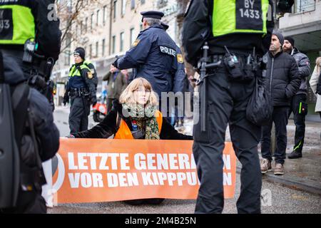 München, Deutschland. 20.. Dezember 2022. Vier Aktivisten der Letzten Generation blockierten die Sonnenstraße in München am 20. Dezember 2022 trotz Anordnung des KVR gegen Kleeblockaden. Im Voraus wurde die Aktion offiziell angekündigt, weshalb viele Polizisten vor Ort waren und 6 weitere Aktivisten stoppten, bevor sie die Straße blockieren konnten. Die Last Generation demonstriert für ein 9-Euro-Ticket und eine Geschwindigkeitsbegrenzung von 100 km/h auf Autobahnen. (Foto: Alexander Pohl/Sipa USA) Guthaben: SIPA USA/Alamy Live News Stockfoto