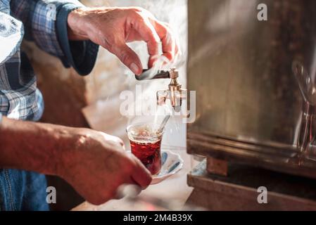 Ein Mann mit einem traditionellen türkischen schwarzen Tee mit Rauch, aus nächster Nähe, im Land der Türkei Stockfoto