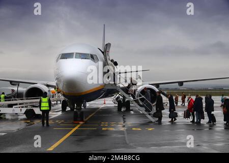 BEAUVAIS, FRANKREICH - 11. DEZEMBER 2019: Passagiere gehen an Bord der Boeing 737 im Regen der Billigfluggesellschaft Ryanair am Flughafen Beauvais, Frankreich. Boarding durch sta Stockfoto