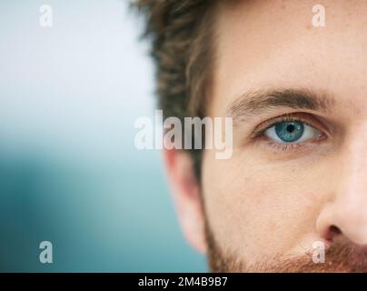 Halb Gesicht, Auge und Mann mit freiem Platz für Werbung und Marketing Augenpflege, Kontaktlinsen und Vision für eine glänzende Zukunft. Makro der blauen Augen des Mannes Stockfoto