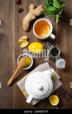 Immunsystem Booster - flacher Laientee mit Ingwer, Honig, Zitrone, Minze und Gewürzen auf dunklem Holzhintergrund. Das Konzept des gesunden Getränks. Draufsicht Stockfoto