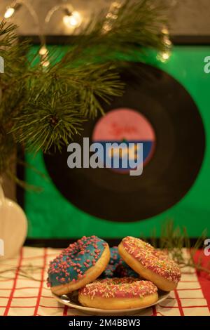 Fotografieren Sie viele bunte Donuts, die auf einem Teller liegen Stockfoto