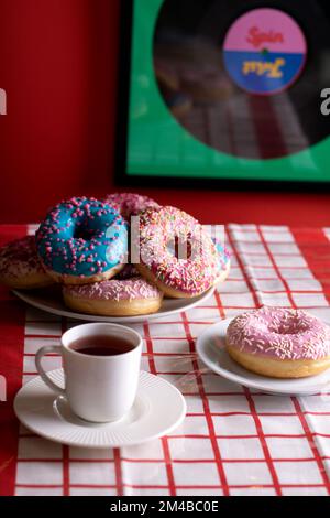 Mehrfarbige Donuts, die auf einem Stapel auf einem Teller liegen Stockfoto