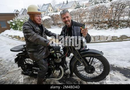 20. Dezember 2022, Sachsen, Seiffen: Motorradsammler Reiner Mattheß (l) besucht den Holzspielzeughersteller Siegfried Werner in Seiffen mit seinem DKW SB 200 ab 1936. Anlässlich der 100-jährigen Produktion von DKW-Motorrädern hat das Holzhandwerksunternehmen eine 8-Zentimeter-Figur des DKW-Gründers Jörgen Skafte Rasmussen in der Rubrik „Saxon Originals“ herausgegeben. Der ersten Reihe von 100 Zahlen folgen weitere. Vor 100 Jahren rollten die ersten seriengefertigten Motorräder bei DKW vom Band. Einige Jahre später wurde das Werk in Zschopau zum weltweit größten Hersteller von Zweirädern. P Stockfoto