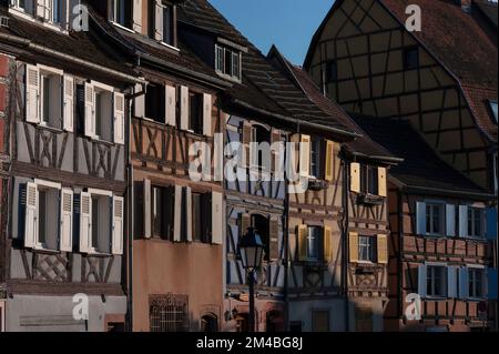 Am späten Abend wird die Sonne über die farbenfrohen Fassaden der antiken Häuser am historischen Quai de la Poissonnerie oder an der Fischhändlerwerft, einem Teil des malerischen kleinen Venedig-Viertels Colmar im Elsass, Grand Est, Frankreich, mit ihren schmalen Fronten, die von einem riesigen Fachwerkgobel umschwärmt werden. Stockfoto