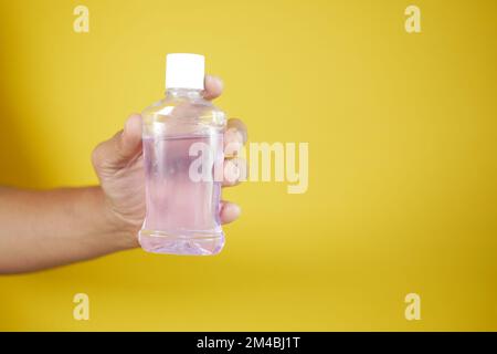 Halten Sie einen Behälter für Mundwasser mit der Hand Stockfoto