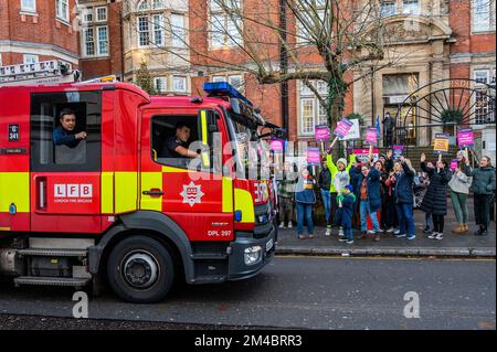 London, Großbritannien. 20.. Dezember 2022. Ein vorbeifahrender Feuerwehrwagen der Londoner Feuerwehr salutiert den Protest mit blauen Lichtern, wenn er vorbeifährt - Eine Streikposte von Krankenschwestern vor dem Royal Marsden Hospital als Teil des vom RCN organisierten Streiks über Krankenpflegegeld. Kredit: Guy Bell/Alamy Live News Stockfoto