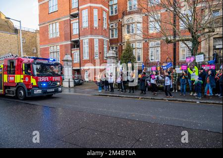 London, Großbritannien. 20.. Dezember 2022. Ein vorbeifahrender Feuerwehrwagen der Londoner Feuerwehr salutiert den Protest mit blauen Lichtern, wenn er vorbeifährt - Eine Streikposte von Krankenschwestern vor dem Royal Marsden Hospital als Teil des vom RCN organisierten Streiks über Krankenpflegegeld. Kredit: Guy Bell/Alamy Live News Stockfoto