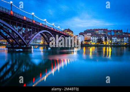 Die Stadt Maribor und Drava River in der Abenddämmerung. Foto aufgenommen am 1.. Dezember 2022 in Maribor, Region Niedersteiermark, Slowenien. Stockfoto