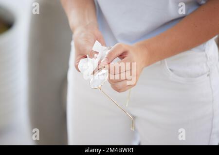 Brillen, Reinigungs- und Frauenhände mit Moderahmen entfernen Staub und Schmutz vom Glas. Optometrie, Augenpflege und Leselinse mit Stoff und Gewebe reinigen Stockfoto