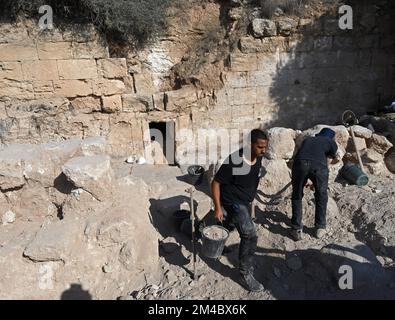 Lachish Forest, Israel. 20.. Dezember 2022. Ein Arbeiter der israelischen Antiquitäten-Behörde transportiert Schmutz vor dem Eingang zur aufwändigen 2.000 Jahre alten Familiengruft aus der zweiten Tempelzeit, bekannt als Salome-Höhle, im Lachischen Wald im jüdischen Tiefland, am Dienstag, den 20. Dezember 2022. Archäologen sagen, dass die Höhle weiterhin in der byzantinischen und frühen islamischen Zeit verwendet wurde und bekannt wurde als die Salome-Höhle aufgrund der Tradition, die sie als Grabstätte von Salome, der Hebamme Jesu, hält. Foto von Debbie Hill/ Kredit: UPI/Alamy Live News Stockfoto