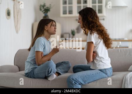 Emotional Teenager Mädchen Tochter kämpfen mit Mutter zu Hause, sitzen vor einander auf dem Sofa Stockfoto