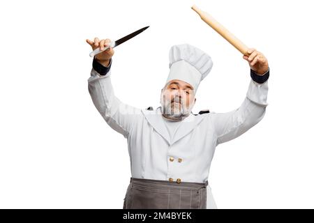 Porträt eines bärtigen Mannes, Restaurantkoch in Uniform, der mit Kochwerkzeugen auf weißem Hintergrund posiert Stockfoto