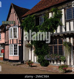 Wohl der berühmteste, ikonischste und fotografierteste Anblick in der alten Wollstadt Lavenham, Suffolk, England, Großbritannien: Vintage Anfang 1900er Gold auf grünem Schild, auf dem Hovis-Brot und -Mehl an der rosa Giebelfassade des 11 Market Place steht, von dem aus die Sparling & Faiers Bäckerei seit 1952 hausgemachtes Brot, Kuchen und Süßwaren serviert. Stockfoto