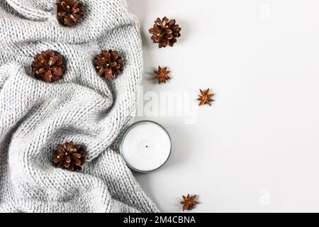 Wintergemütliches Gemälde aus Strickpullover, Kerzen, Pinienzapfen, Sternanissternen. Stockfoto