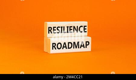 Roadmap-Symbol für Resilienz. Konzeptbegriff „Resilience“-Roadmap auf Holzblöcken getippt. Schöner orangefarbener Tischhintergrund. Business und Resilienz r Stockfoto