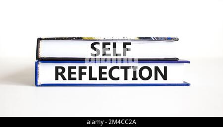 Symbol für Selbstreflexion. Das Konzeptwort Selbstreflexion in Büchern. Wunderschöner weißer Tischhintergrund. Betriebspsychologie und Selbstreflexion Stockfoto