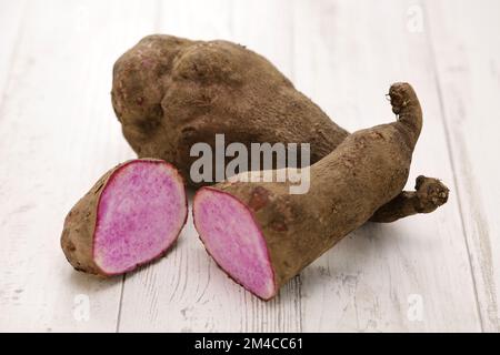 Violette Yamswurzeln isoliert auf weißem Holzhintergrund Stockfoto