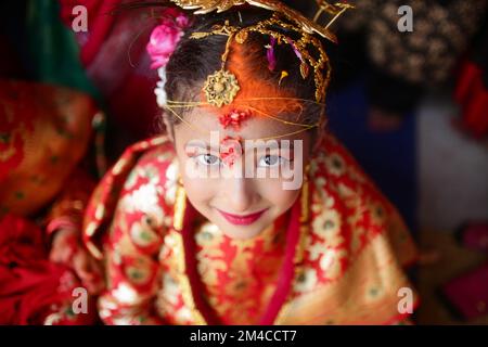 Bhaktapur, Nepal. 20.. Dezember 2022. Ein kleines Mädchen führt das traditionelle Ritual zusammen mit ihren Freunden während der Gufa-Zeremonie in Bhaktapur, Nepal, durch. Gufa ist eine traditionelle Zeremonie der Newar-Gemeinde, bei der Mädchen im Alter von 12-14 Jahren vor ihrer ersten Mensuration mit dem Sonnengott verheiratet werden. Das Mädchen, das das Ritual trägt, muss 12 Tage lang leben und der Sonne und den männlichen Familienmitgliedern aus dem Weg gehen. Nach Abschluss des Prozesses wird das Mädchen am 12.. Tag aus dem Zimmer gebracht und gebeten, in die Sonne zu schauen. (Kreditbild: © Amit Machamasi/ZUMA Press Wire) Stockfoto