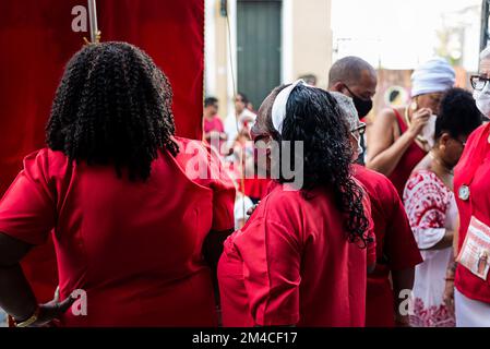 Salvador, Bahia, Brasilien - 04. Dezember 2022: Anhänger von Santa Barbara, die während der Messe im Largo do Pelourinho in der Stadt Salvador rot gekleidet waren. Stockfoto