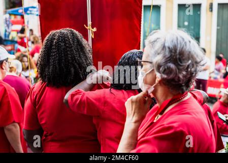 Salvador, Bahia, Brasilien - 04. Dezember 2022: Anhänger von Santa Barbara, die während der Messe im Largo do Pelourinho in der Stadt Salvador rot gekleidet waren. Stockfoto