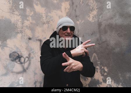 Reifer Rap-Sänger, der sich auf der Straße am Stadtrand einer Großstadt posiert Stockfoto