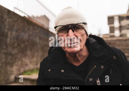 Reifer Rap-Sänger, der sich auf der Straße am Stadtrand einer Großstadt posiert Stockfoto