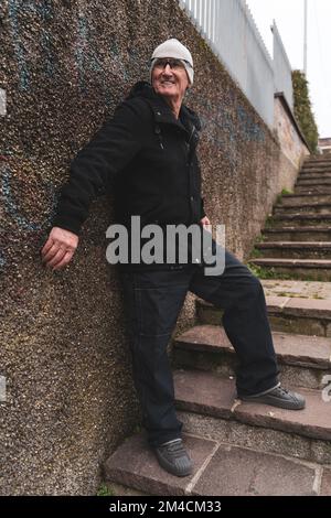 Reifer Rap-Sänger, der sich auf der Straße am Stadtrand einer Großstadt posiert Stockfoto