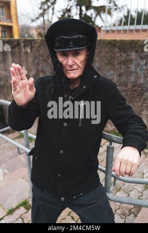 Reifer Rap-Sänger, der sich auf der Straße am Stadtrand einer Großstadt posiert Stockfoto