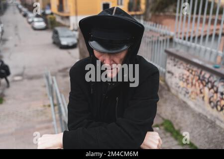 Reifer Rap-Sänger, der sich auf der Straße am Stadtrand einer Großstadt posiert Stockfoto