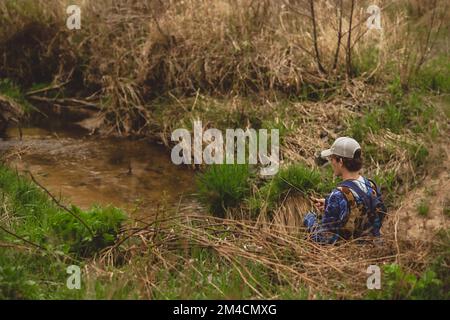 Junger Mann, der im Bach angeln will Stockfoto