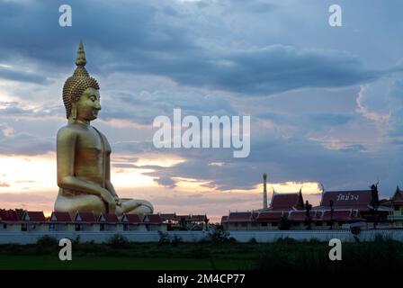 Sonnenuntergang von Phra Buddha MahaNawamin, diese riesige Buddha-Statue ist 92m m hoch, es ist die kleinste Statue der Welt in Wat Muang, Thailand. Stockfoto