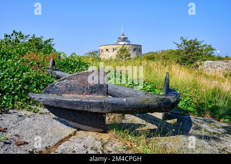 Unterwegs auf den Ertholmen-Inseln, rostigem Schiffsanker sowie dem Großen Turm (Store Tårn) und Leuchtturm, Christiansö, Ertholmene, Dänemark. Stockfoto