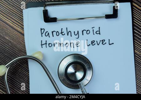 Konzept des Parothyroidhormonspiegels Schreibarbeiten mit Stethoskop auf Holztisch. Stockfoto