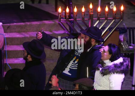 Toronto, Kanada. 19.. Dezember 2022. Lubavitcher Rabbis machen ein Selfie, während Juden Chanukah mit der Beleuchtung einer riesigen Eismenorah feiern, während der zweiten Nacht des jüdischen Feiertages von Chanukka (Chanukah) in Toronto, Ontario, Kanada, am 19. Dezember 2022. (Foto von Creative Touch Imaging Ltd./NurPhoto) Kredit: NurPhoto/Alamy Live News Stockfoto