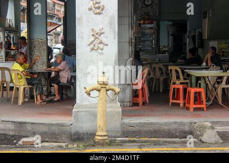 Georgetown, Penang, Malaysia - November 2012: Gäste essen in einem alten Café in der historischen Stadt George Town, Penang. Stockfoto