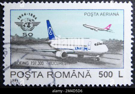 ISTANBUL, TÜRKEI - 24. JANUAR 2021: Rumänischer Stempel zeigt ICAO, 50. Jubiläum, Tarom Boeing 737-300 um 1994 Stockfoto