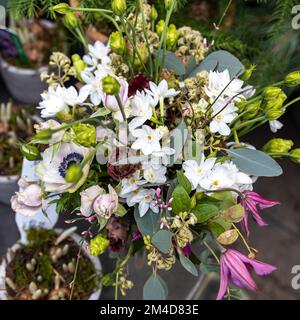 Verschiedene Farben in der Nähe des Liberty Stores in London. Große Blumensträuße in Zinnvasen. Wiesen-Narzissen, Anemone, Eukalyptusäste, Lisianthus im Stockfoto