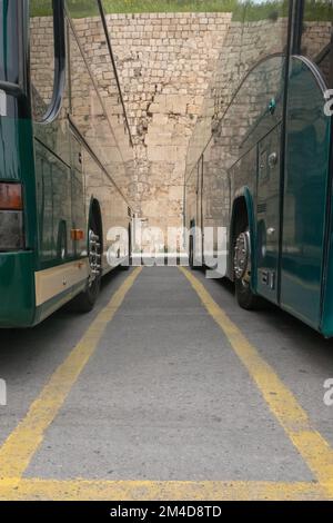 Niedriger Winkel mit Blick auf einen Busparkplatz. Nahaufnahme der grünen Busse in Griechenland. Stockfoto