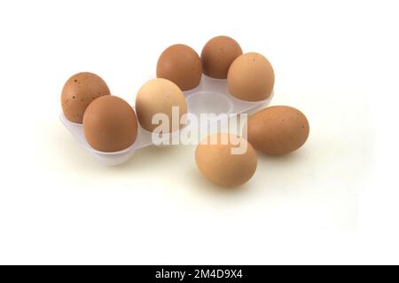 Eine vordere Ebene eines Eiertabletts mit zwei Eiern auf dem Tisch, außerhalb des Tabletts Stockfoto