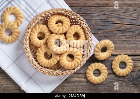 Shortbread-Kekse in einer Korbschale und in der Nähe auf einem Holztisch, Draufsicht Stockfoto