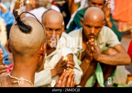 Ein Priester ist die Unterstützung von Beten Ritual für die gute Reinkarnation eines verstorbenen Person an Har-Ki-Pauri-Ghat in Haridwar Stockfoto