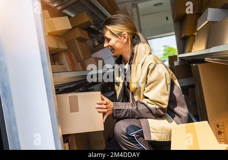 Lieferstelle sucht nach Paketen für Lieferwagen, um sie an einen Kunden zu liefern Stockfoto